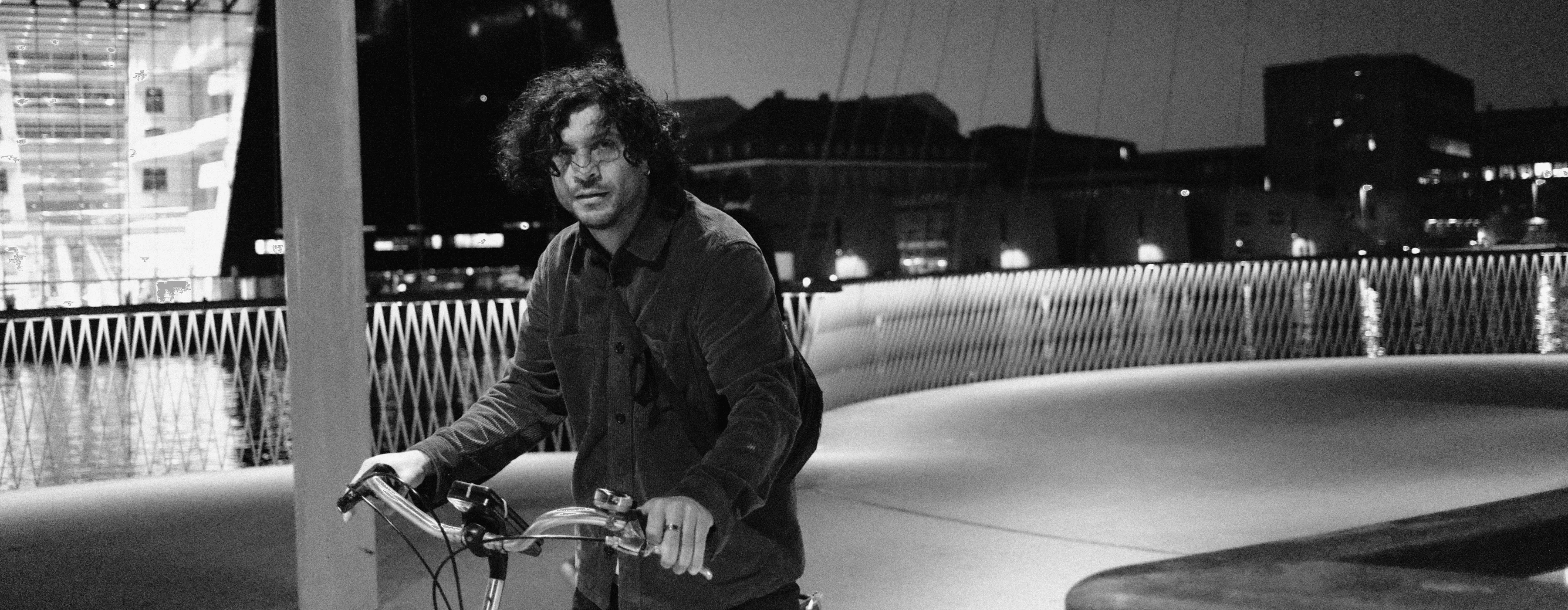 Alper Aytac with a bike on a bridge at night